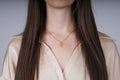 Gouden kruisketting met roze kristallen