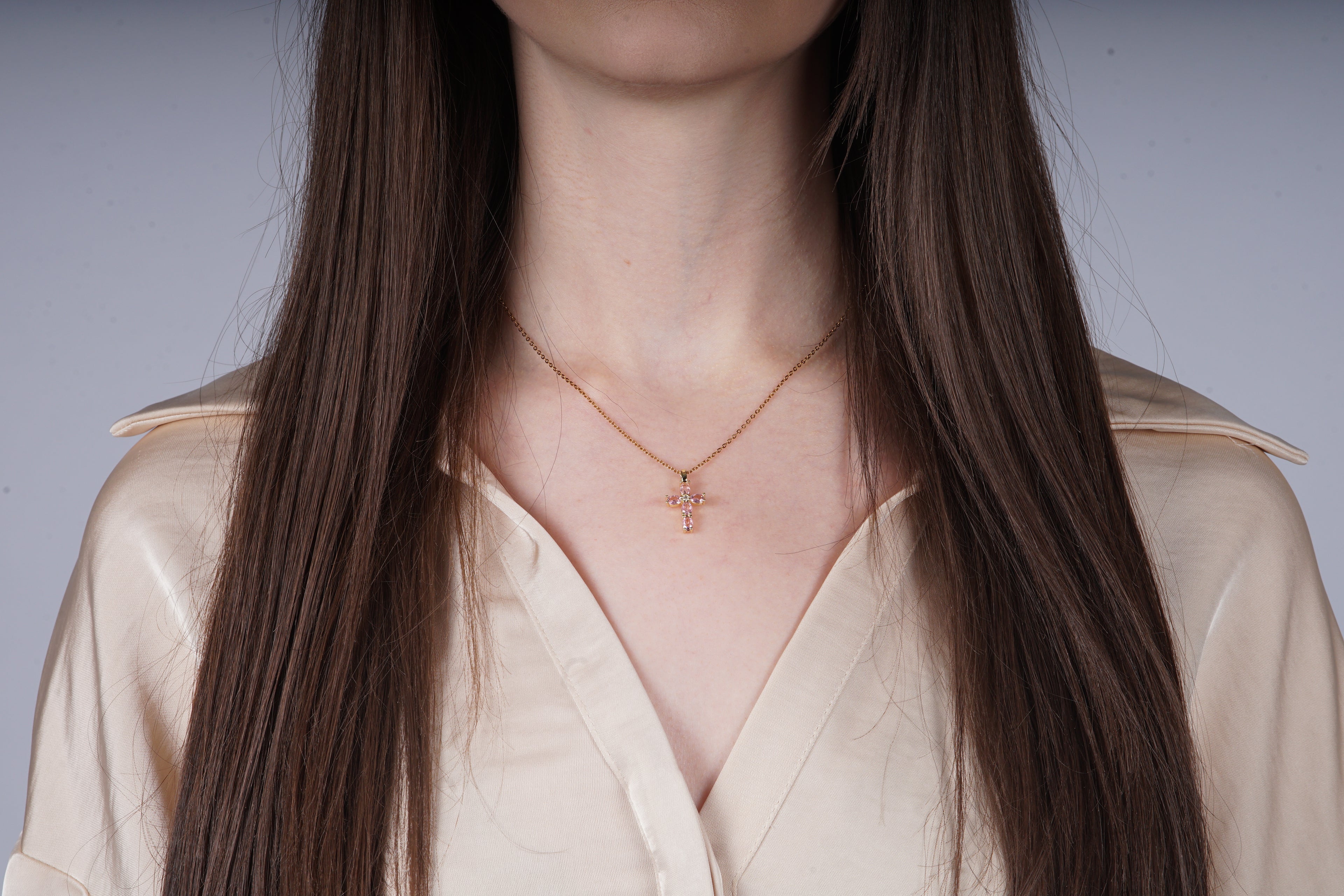 Gouden kruisketting met roze kristallen