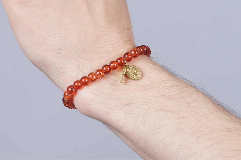 Zadelbruine armband met een kruizen bedel en een Virgin Maria bedel