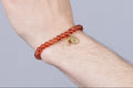 Zadelbruine armband met een kruizen bedel en een Virgin Maria bedel