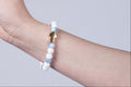 Blauw witte armband met een kruizen bedel