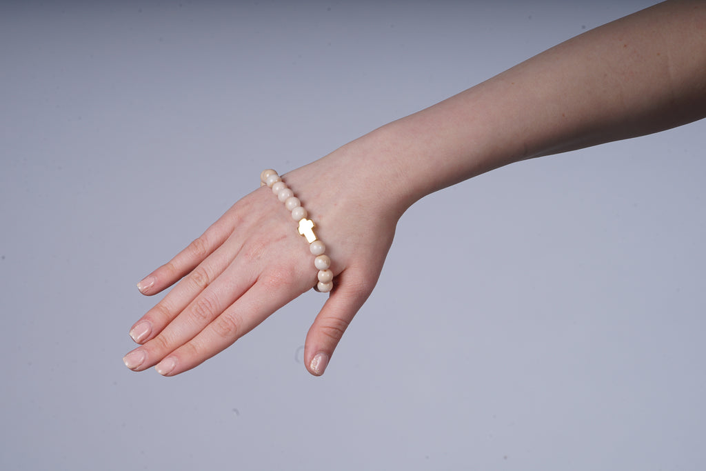 Beige armband met een kruis bedel