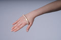 Beige armband met een kruis bedel