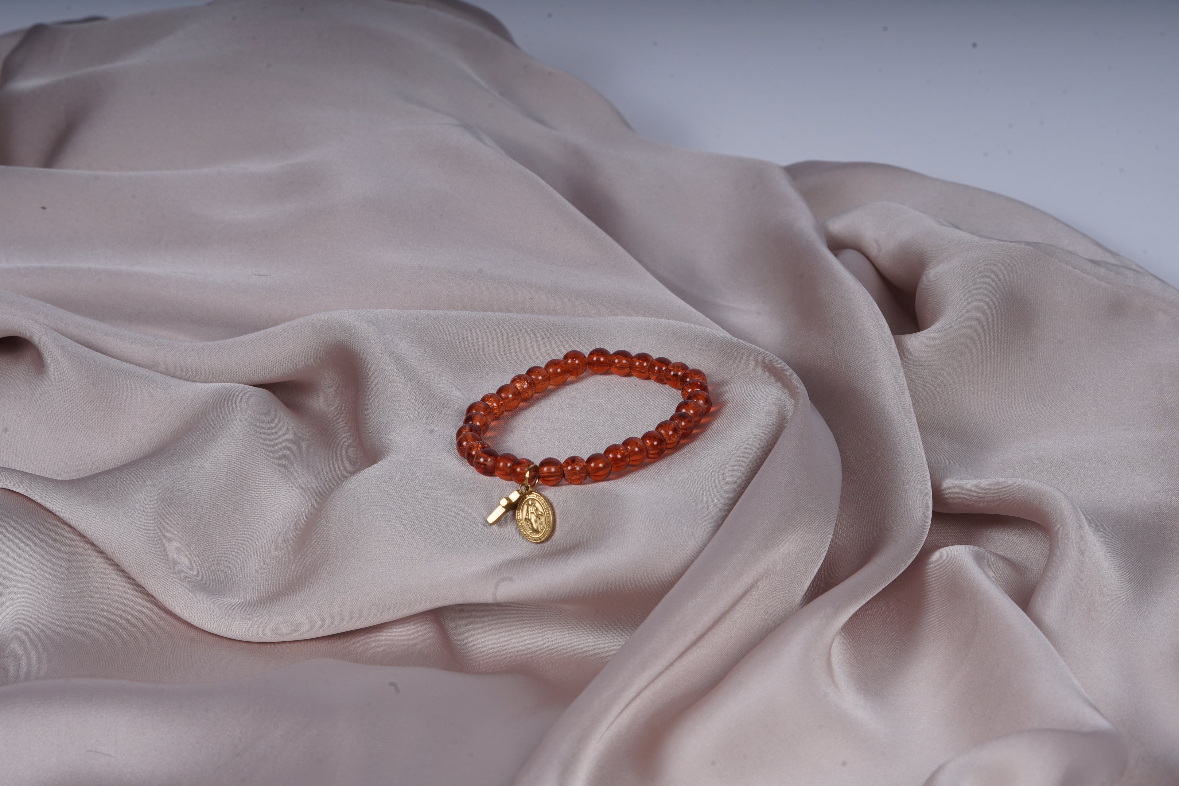 Zadelbruine armband met een kruizen bedel en een Virgin Maria bedel