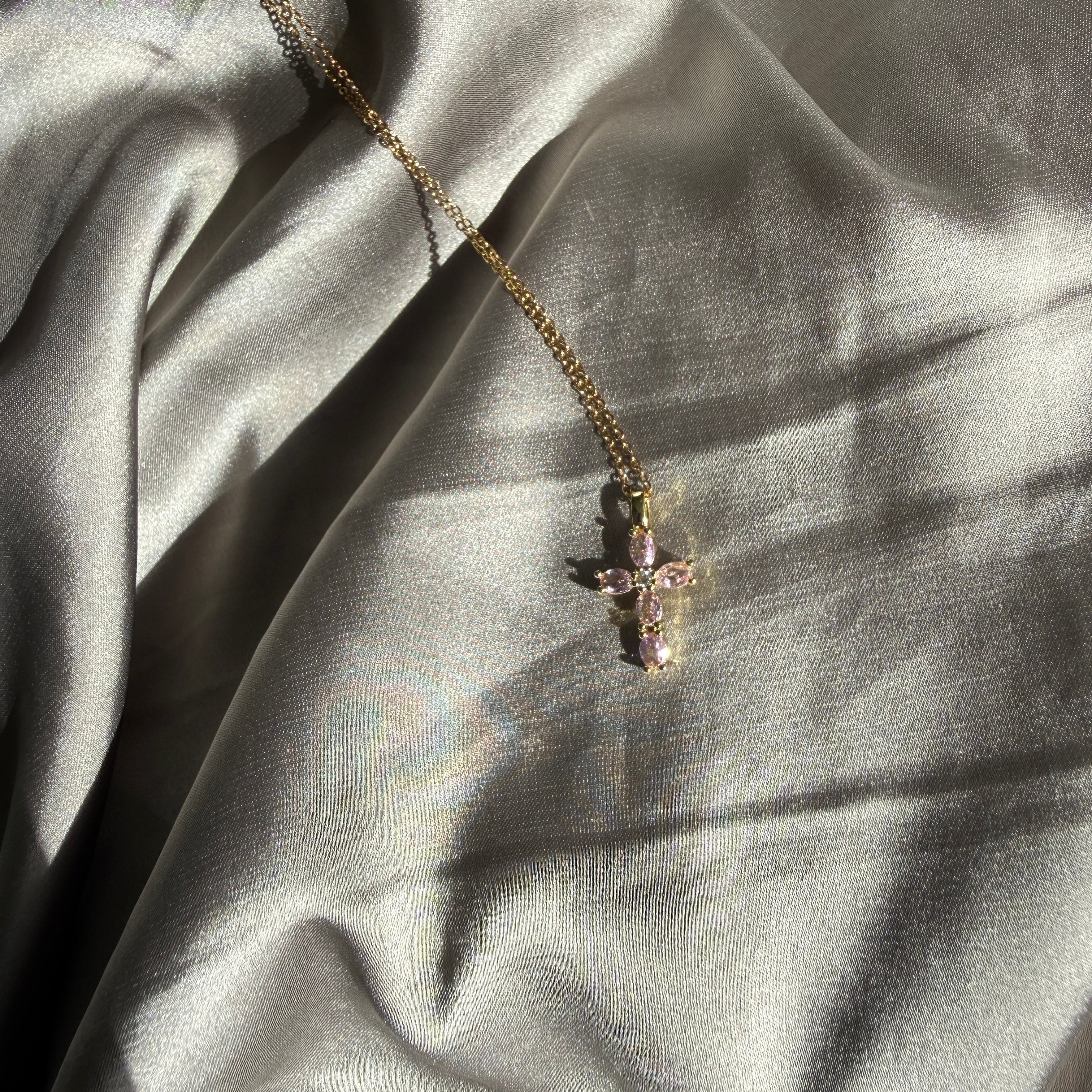 Gouden kruisketting met roze kristallen